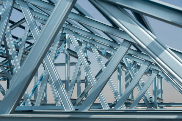 Structure of steel roof frame for building construction on sky background.
